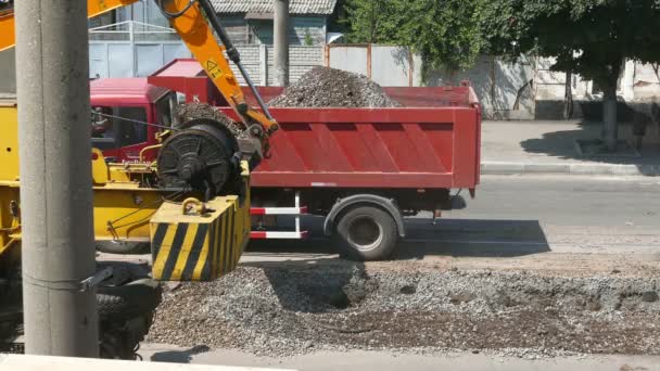 Reparaciones de carreteras, excavadora llena el camión de escombros — Vídeos de Stock