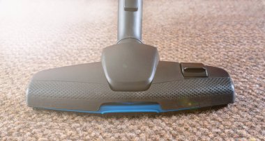 Kahverengi halıya yakın çekimde elektrikli süpürge