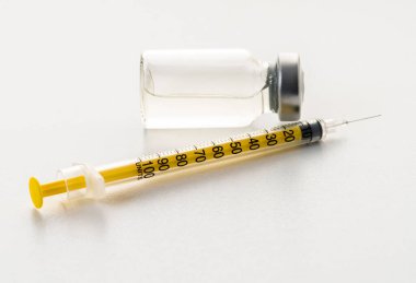 Beyaz arka planda şırınga ve ilaç şişesi