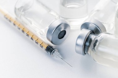 Beyaz arka planda şırınga ve ilaç şişesi