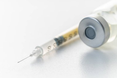 Beyaz arka planda şırınga ve ilaç şişesi