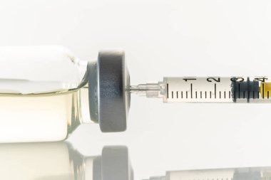 Beyaz arka planda şırınga ve ilaç şişesi