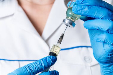 Sıvı ilaç ya da tedavi aşısı, doktorun elinde grip.