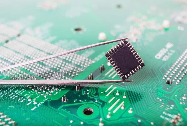 Microchip in the tweezers closeup — Stock Photo, Image
