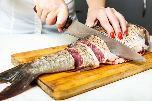 Girl knife cut the fish into slices — Stock Photo, Image