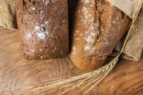 Dos panes negros con espigas de trigo —  Fotos de Stock