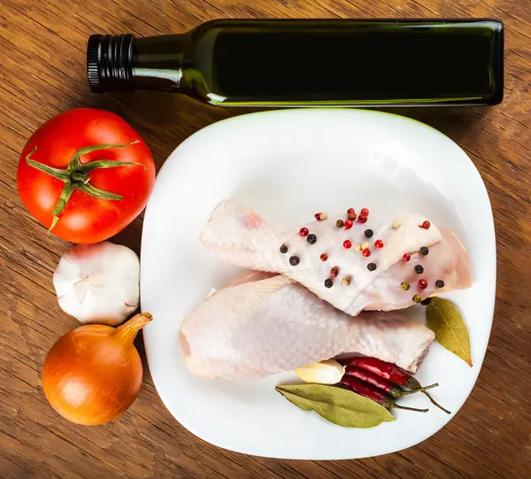 Chicken legs on the plate with spices and vegetables — Stock Photo, Image