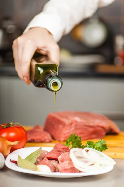 Chef-kok giet olijfolie — Stockfoto