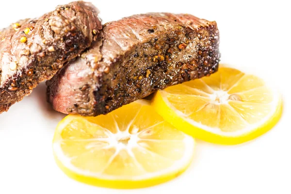 Sliced roasted meat with slices of lemon closeup — Stock Photo, Image