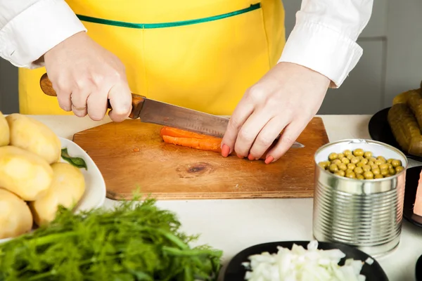 Woman cuts a knife carrot — Stock Photo, Image