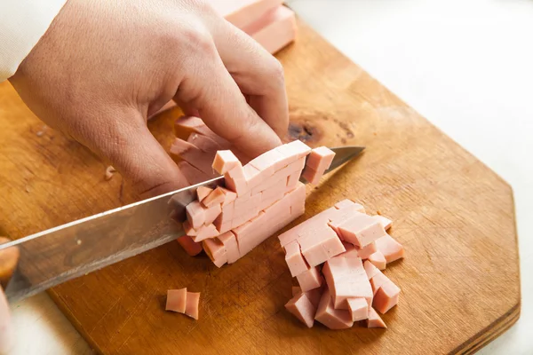 Kvinnliga händer skära korv — Stockfoto