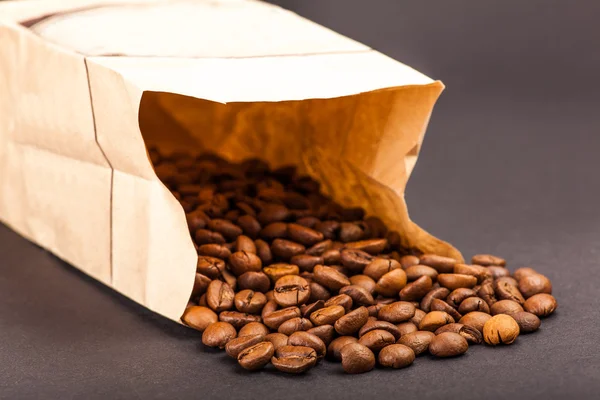Papírový sáček naplněný kávová zrna — Stock fotografie