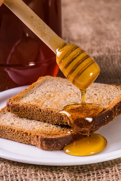 カリカリ トーストに蜂蜜が注がれる — ストック写真