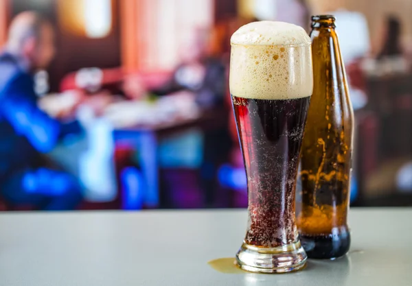 Стакан тёмного пива и бутылки — стоковое фото
