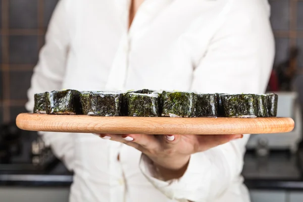 Cook holds plate with rolls — Stock Photo, Image