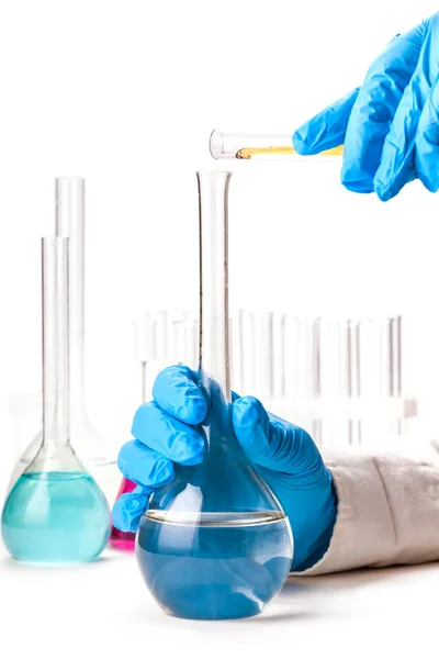 Assistant reagent pours into the flask from a test tube — Stock Photo, Image