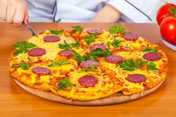 Kocken innehar en bit pizza — Stockfoto