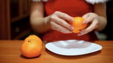 kadın bir mandalina temizler