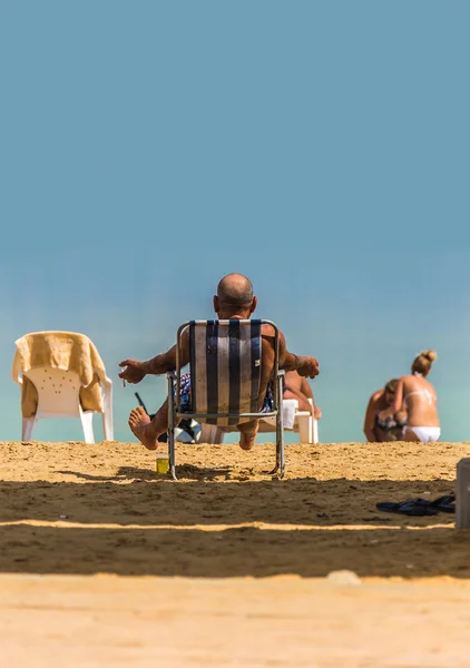 Människor koppla av på stranden döda havet — Stockfoto