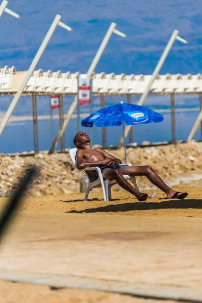 Hommes se détendre sur la plage Mer Morte — Photo