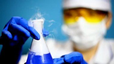 laboratorian şişeye içeriğini inceler