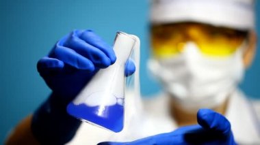 laboratorian şişeye içeriğini inceler