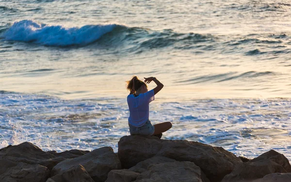 Femme assise au bord de la mer — Photo