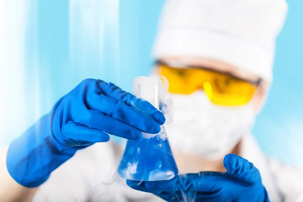 Chemikerin untersucht Reagenzglas — Stockfoto