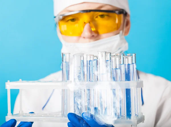 Química mujer examina tubo de ensayo — Foto de Stock