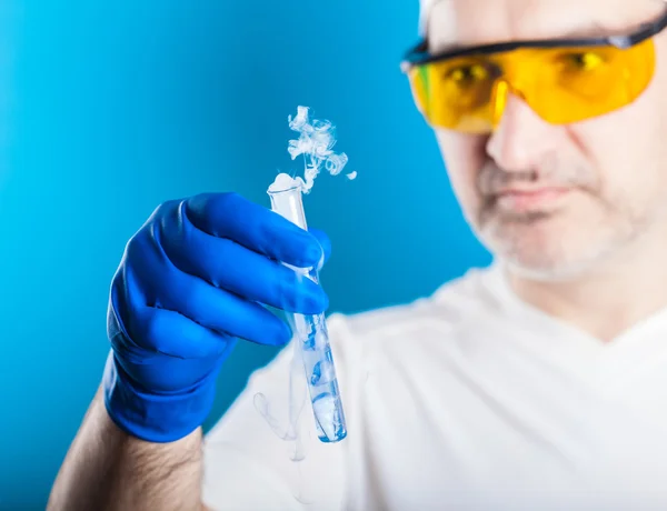 Muž chemik zkoumá zkumavky — Stock fotografie