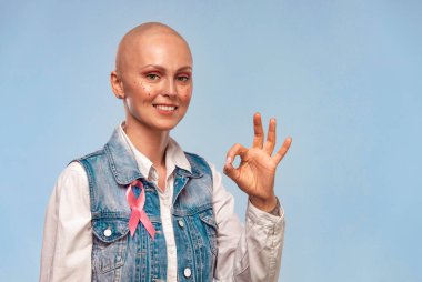 Sağlık ve tıp konsepti. Pembe meme kanseri farkındalığı olan kel bir kadın. Kopya alanındaki mutlu kız noktaları