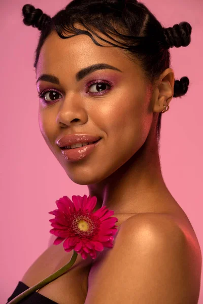 Porträt lächelnder junger afroamerikanischer Frauen mit Blumen. Frühjahrs- oder Sommerkonzept. Stockfoto