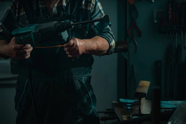 Älterer Mann mit Werkzeug arbeitet in Werkstatt lizenzfreie Stockbilder