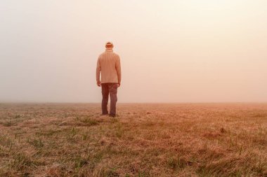 Genç adam gün doğumunda sisli bir sonbahar sabahı sisinde yürüyor. Çek manzarası