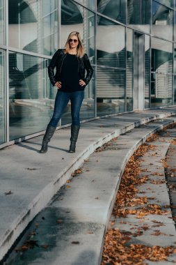 İş binasının önünde duran çekici, beyaz tenli sarışın kadının portresi.