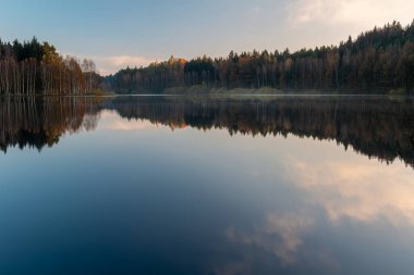 Çek sonbahar yapraklarının manzarası sisli sis ile Rimov barajına yansıdı