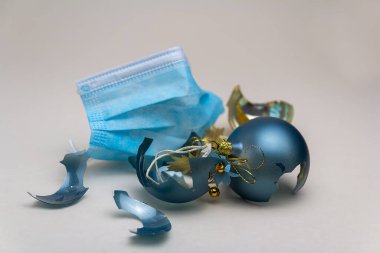 Kırık Noel topları olan yüz maskesi. Salgın covid 19 Noel tatilini iptal etti