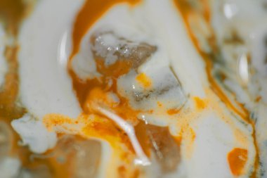 Parlak turuncu renkler beyaz arka planda birbirine karışıyor. Boyama, mermer sıçrama, soyut doku.