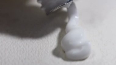 Beyaz yüzeydeki tüpten sıkma losyonu, görüntüyü kapat