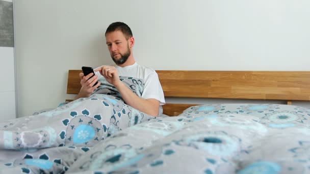 Jong Volwassen Man Met Behulp Van Smartphone Bed — Stockvideo