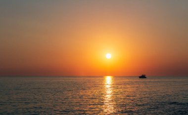 Küçük yatın silueti, gün batımında denizde yüzen gemi. Istria, Hırvatistan