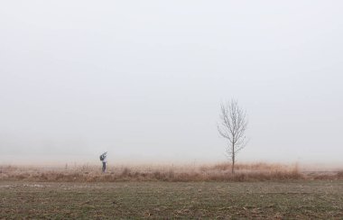 Beyaz kapüşonlu ve sırt çantalı bir adam buz gibi Çek topraklarında yolda yürüyor. Aktif, sağlıklı yaşam tarzı