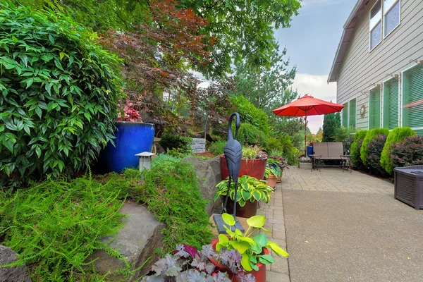 Cour arrière de jardin avec siège de patio et parapluie — Photo