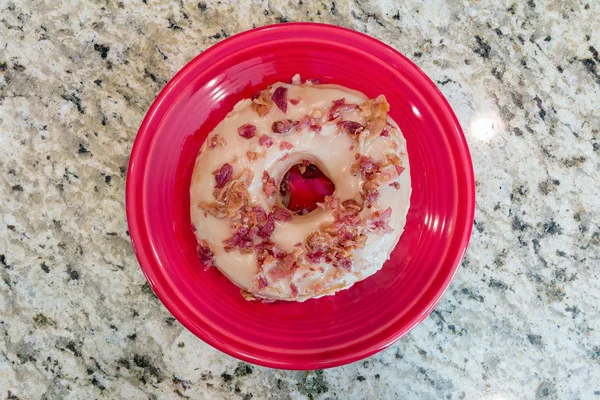 Bacon och lönn donut på röd tallrik — Stockfoto