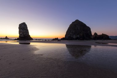 Güneş battıktan sonra top plajda Haystack Rock