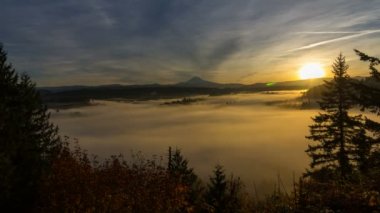 Zaman atlamalı film hareketli sis ve kar kaplı Mt. Hood bir erken sabah güneş doğarken 1080 p ile alçak bulutlar