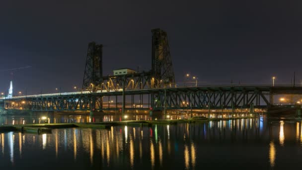 Time Lapse film av lång exponering timme trafiktoppar på stål bro med färgglada vatten eftertanke längs Willamette River i centrala Portland Oregon på natten 1080p — Stockvideo