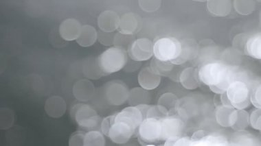 Odak dışında parlak gümüş Bokeh daire noktalar arka plan film 1080 p su