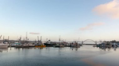 Ultra yüksek çözünürlüklü 4k zaman atlamalı film beyaz bulutlar ve su yansıma tekneler ve Yaquina Körfez Köprüsü Newport Oregon ile mavi gökyüzü
