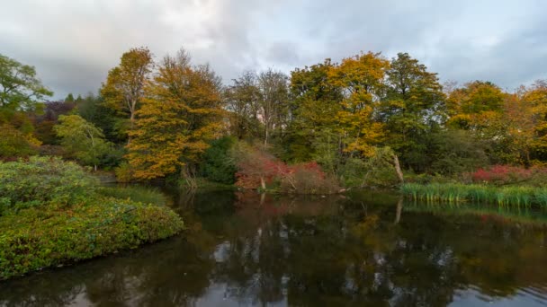 UHD 4k Time Lapse film de nuages mouvants sombres sur l'eau de l'étang réflexion avec automne couleurs dans Crystal Springs Garden 4096x2304 